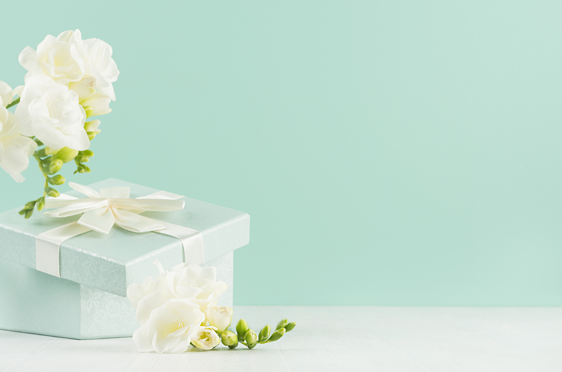 Opened Gift Box with Flowers on Green Mint Background